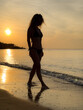© Sunny studio - Silhouette of young woman relaxing at the beach