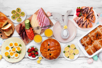 Wall Mural - Easter breakfast or brunch table scene. Top view on a white wood background. Breads, quiche and an assortment of spring food items.