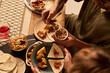 © pressmaster - Friends enjoying a meal featuring tortillas, beans, and other traditional Hispanic dishes, sitting around a wooden table with vibrant place settings