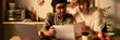 © pressmaster - Couple with paper documents sitting at kitchen table with laptop, discussing finances and reading documents together. Room adorned with simple decor and natural light