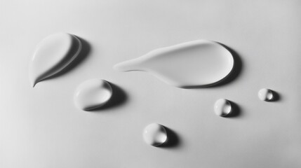 Poster - Delicate water droplets rest on a smooth, polished surface, creating an artistic interplay of light and shadow. Their shapes vary, captivating with their serene simplicity