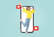 © Prostock-studio - A young woman joyfully interacts with her smartphone, expressing excitement and engagement in social media. Bright colors enhance the theme of love and connection, perfect for Valentine's Day.