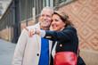 © Jose Calsina - A Engaged, Mature Couple Stroll Hand in Hand Through the Lively, Charming City Streets, Pointing Out Sights and Conversing with Genuine Affection, Enthusiasm. Mid Adult People Sightseeing Outside
