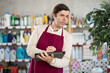 © JackF - Adult man seller in uniform conducting inventory with tablet in household chemicals store