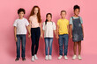 © Prostock-studio - School friendship. Adorable multiethnic children holding hands together on pink background
