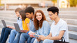 © Prostock-studio - Group Of Students Learning Using Gadgets Sitting On College Steps Outdoor Preparing For End-Of-Semester Exams Together.
