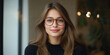 © Andres Mejia - Portrait of smiling young woman wearing stylish eyeglasses in modern office