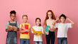 © Prostock-studio - Multinational group of kids with books and notebooks ready for school over pink studio background