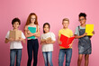 © Prostock-studio - Portrait of multiethnic kids with textbooks and notebooks ready to start new school year on pink background