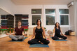 © phoenix021 - Two women and young man meditating together with their eyes closed in yoga studio