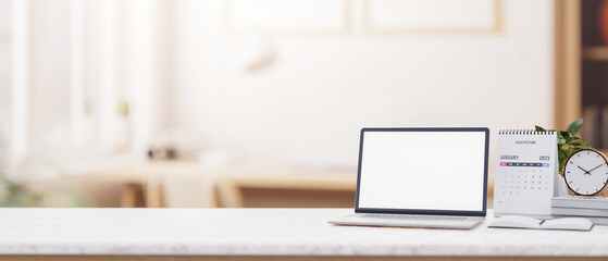 Wall Mural - a minimalist white desk features a laptop with a white screen mockup in a minimalist office.