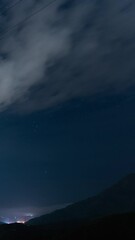 Wall Mural - starry sky and city lights time lapse, vertical view
