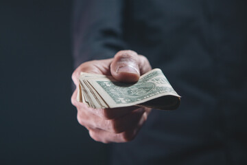 Wall Mural - man holding money on black background