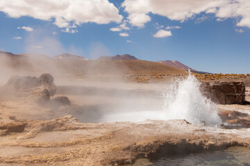 Tatio Geyser, Atacama Desert, Chile. Geyser steam in the desert with blue sky and clouds.