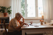 © Halfpoint - Elderly woman looking sadly at few banknotes on table. Concept of financial concerns for seniors.