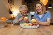 © Halfpoint - Portrait of elderly companion assistant and senior woman peeling potatoes. Home health care services.