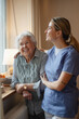 © Halfpoint - Caring healthcare worker visiting senior patient at home, holding her around shoulders.