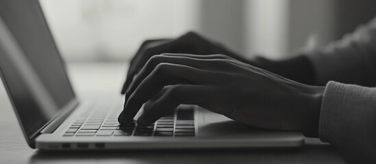 Hands typing on laptop indoors