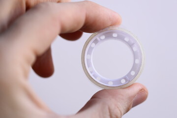 Poster - A person holds a piece of tape in their hand, possibly for a DIY project or repair.