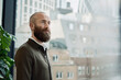 © Westend61 - Thoughtful bearded businessman near glass wall at office