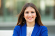 © Minerva Studio - Young businesswoman smiling with blue jacket in urban setting