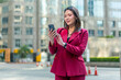 © StockPhotoRepublic - Confident Asian Businesswoman in Red Suit Using Phone Outdoors in Modern City