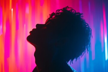 Poster - Silhouette of a person against colorful light display in a creative art space