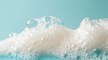 Poster - A captivating display of soap foam bubbles rests gracefully against a soothing blue background, highlighting the intricate textures and forms