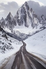 Wall Mural - A snow-covered road leading to a majestic mountain landscape