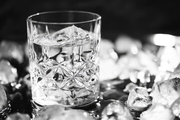 Poster - A clear glass filled with ice sitting on a table