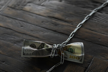 Wall Mural - Secured Hundred Dollar Bill Bound with Chain and Lock on Wooden Surface