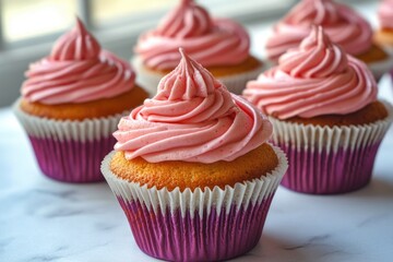 Wall Mural - A close-up view of decorated cupcakes with pink frosting on a table, perfect for food photography or as a design element