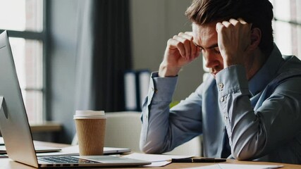 Poster - Office worker suffering from intense stress related headache while working at desk, experiencing mental strain and physical tension in workplace environment