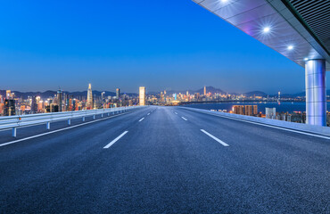 Wall Mural - An empty road leads to the city skyline at night