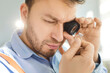 © Studio Romantic - Close up of skilled jeweler closely inspecting gemstone in ring with magnifying glass. Expert craftsman carefully analyzing details, demonstrating precision and mastery in jewelry making and repair.