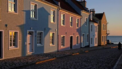 Aufkleber - Colorful houses line a waterfront street at sunset in a coastal town