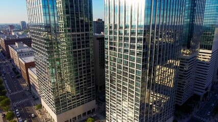 Poster - Sunlight reflecting on sleek glass facades of high rise buildings, illuminating vibrant urban landscape and signaling economic dynamism of contemporary city center