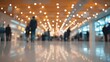 © arhendrix - Out-of-focus convention hall with warm lighting, business professionals shaking hands in the distance, corporate networking concept.