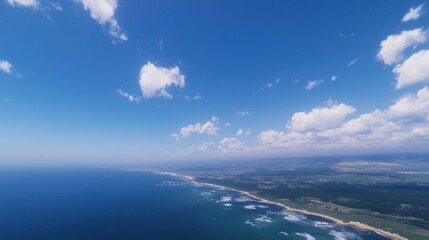 Wall Mural - A stunning aerial view of a coastline with blue ocean and fluffy clouds.