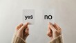 © olga_demina - Woman holding two white cards labeled yes and no, representing the challenge of decision making in career, relationships, and personal growth
