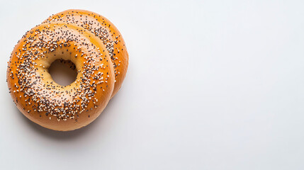 Two fresh bagels adorned with seeds, ideal for breakfast or a light snack, presented on a clean white background with ample copy space.