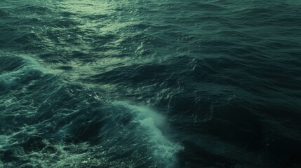 Wall Mural - a serene view of dark ocean waves gently rolling under a twilight sky.