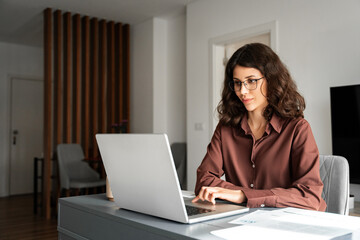 Canvas Print - Young freelance business woman using laptop computer for online remote programmer work. Latin hispanic or middle eastern girl student watching webinar studying lesson. Businesswoman working remotely