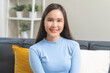 © KMPZZZ - Smile positive, attractive confident asian young woman, girl wearing casual sitting on sofa, couch at home, portrait of beautiful female brunette hair, feeling happy comfortable looking at camera.