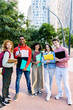 © Xavier Lorenzo - Vertical shot of diverse group of five teenage student friends standing together outside. Portrait of young multiracial college people team smiling at camera. Youth community and friendship concept