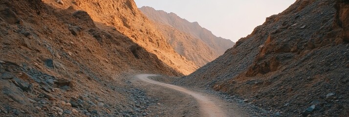 Poster - Golden hour sunlight illuminates the rugged slopes of a desert canyon as a winding dirt road stretches into the distance, inviting exploration and adventure