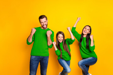 Wall Mural - Photo of stylish trendy day excited crazy family with daddy mommy and their daughter screaming with victory saying yes wearing jeans denim isolated over vivid yellow color background