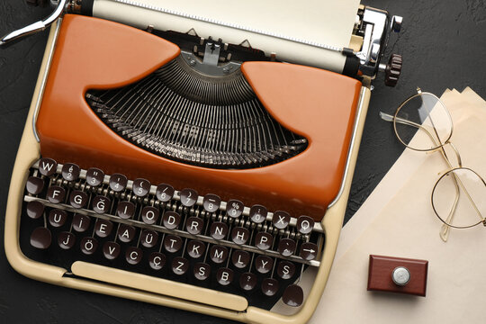 Flat lay composition with vintage typewriter on black background