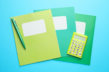 Wall Mural - Copybooks, calculator and pen on light blue background, top view