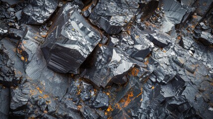 Aufkleber - Shiny black mineral rocks with sharp edges are featured in a close up view, highlighting their unique textures and vibrant orange hues among black surfaces in natural light.